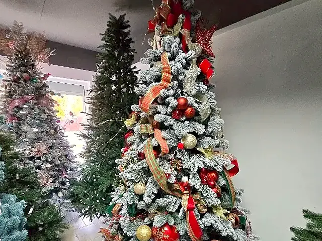 Brad artificial înzăpezit, decorat cu globuri roșii și aurii, în showroom-ul Depozitul de Brazi din Chiajna